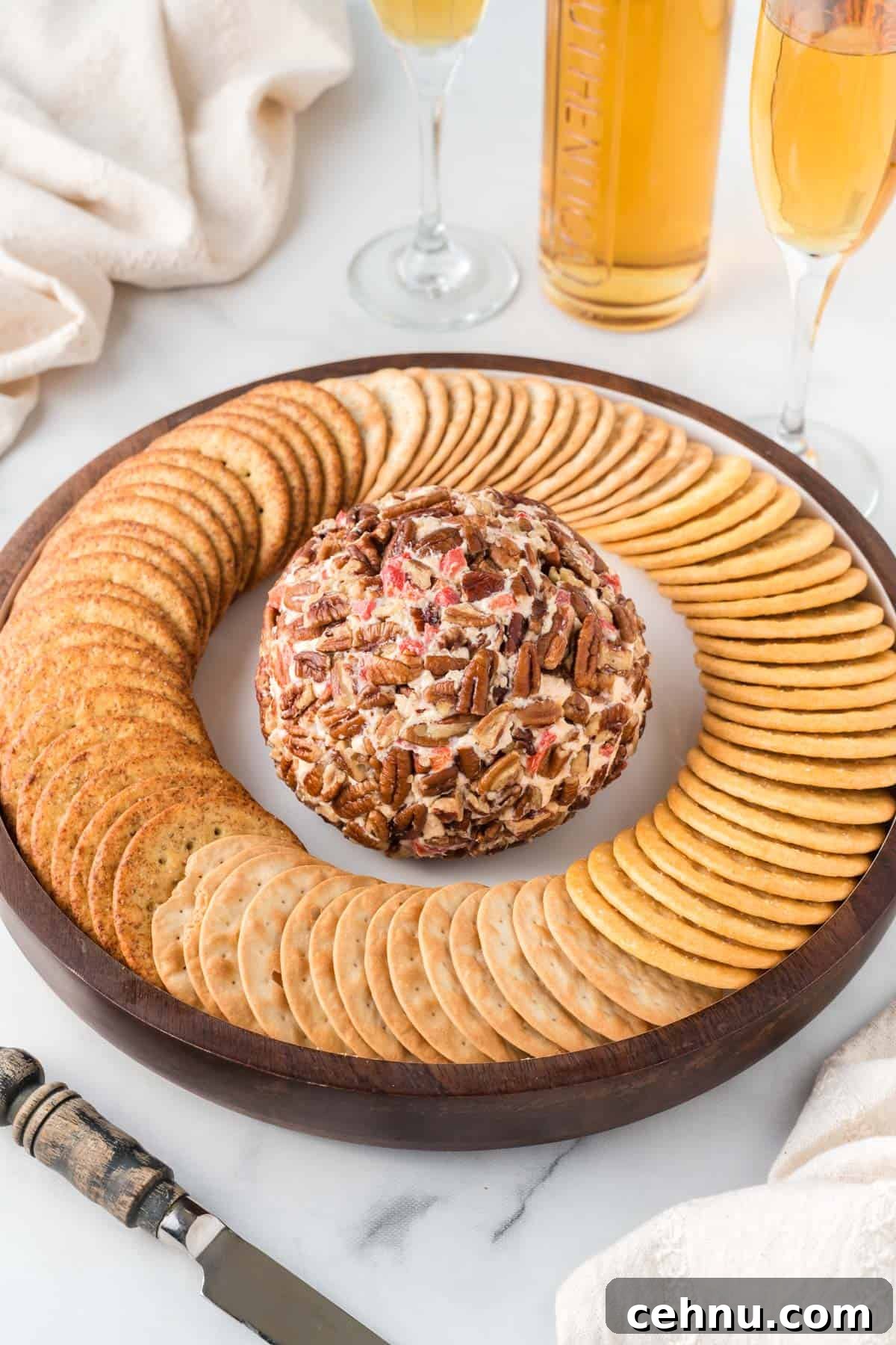 pimento cheese ball on a platter surrounded by crackers