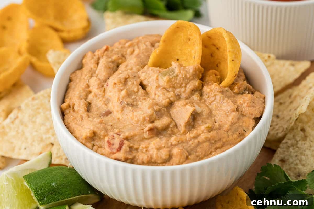 bean dip in a white bowl with tortilla chips