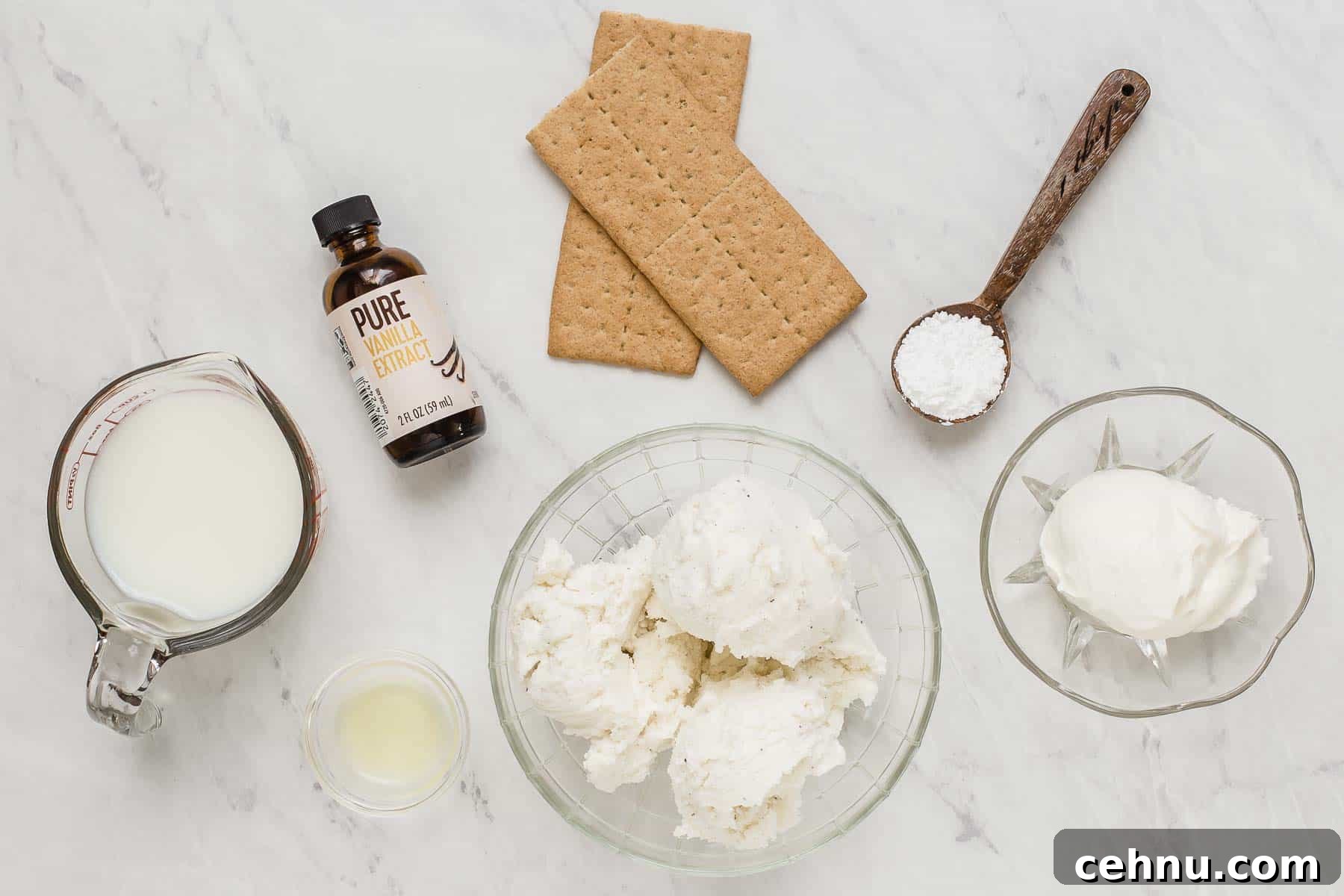 Ingredients for cheesecake milkshakes on white marble table.