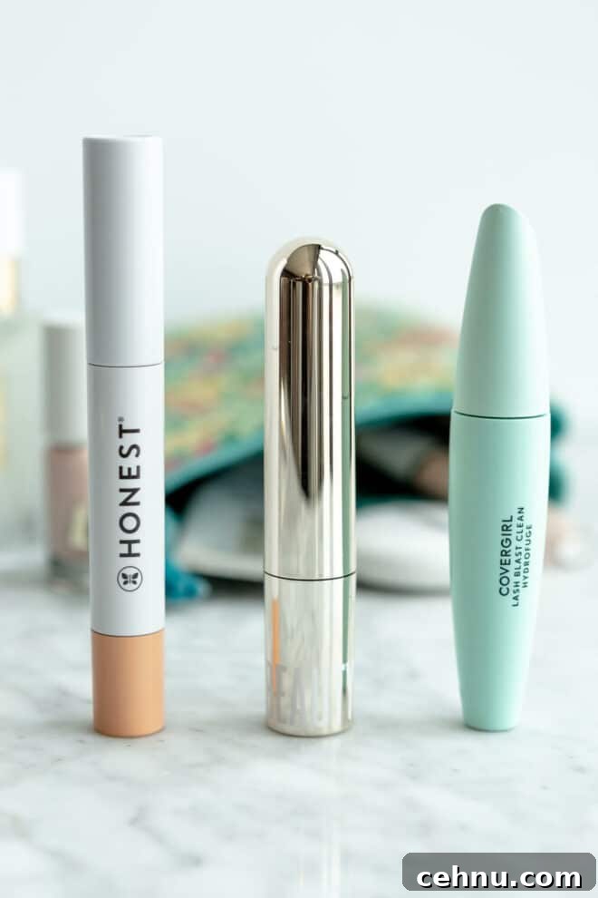 Clean Mascara for Longer Lashes Without Harsh Ingredients 2 Three mascaras lined up on a grey and white marble surface with a makeup bag in the background.