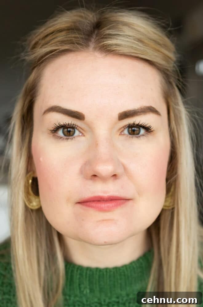 Clean Mascara for Longer Lashes Without Harsh Ingredients 4 Headshot of Lauren in a Kelly green sweater not smiling wearing Honest mascara.