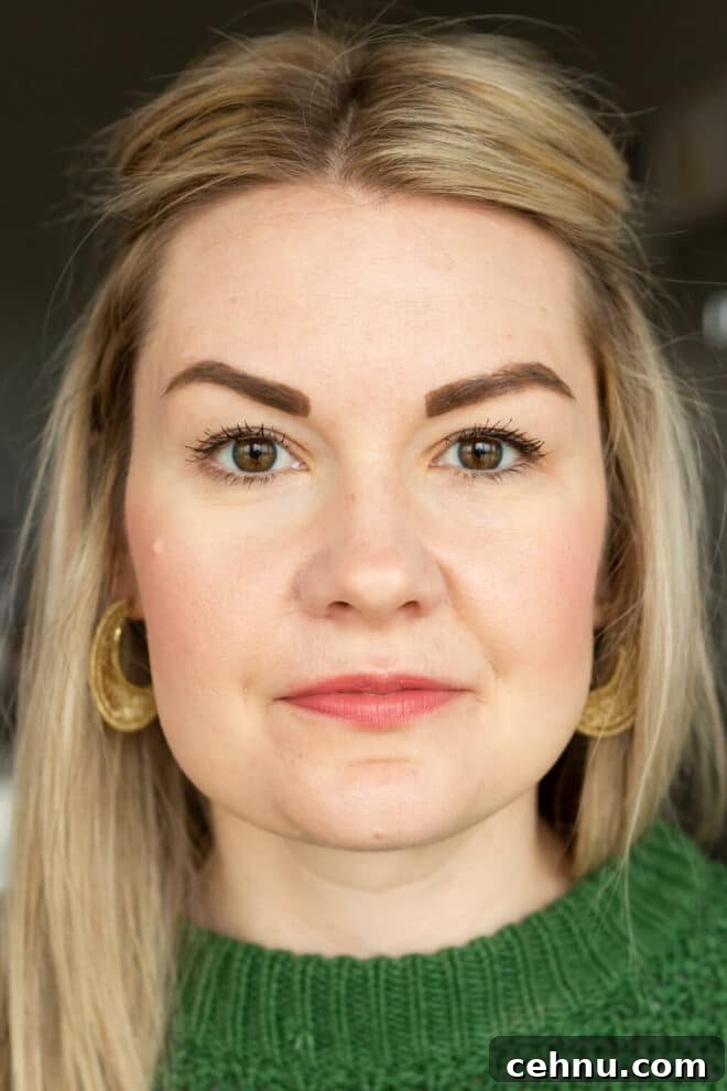 Clean Mascara for Longer Lashes Without Harsh Ingredients 5 Headshot of Lauren in a Kelly green sweater not smiling wearing Cover Girl mascara.