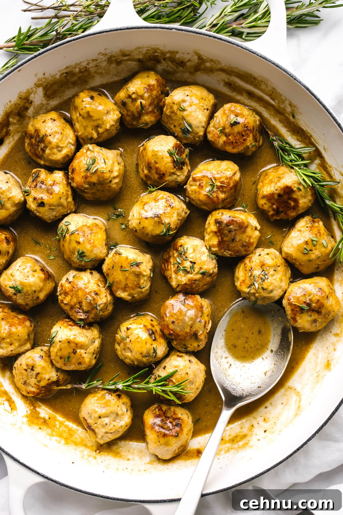 Thanksgiving Menu Ideas and Classic Holiday Recipes 14 Turkey meatballs in a pan with maple mustard sauce with a spoon.