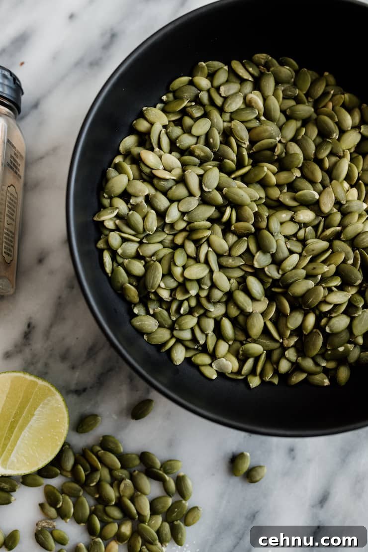 How to Make Spicy Roasted Pepitas (Pumpkin Seeds) 4 raw pepitas, also known as pumpkin seeds, in a black bowl on a marble countertop