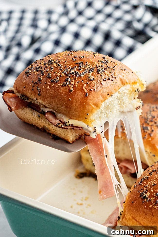 Ham and Swiss Sliders Recipe with Honey Mustard Glaze 7 cheesy pull from a hot slider on a spatula