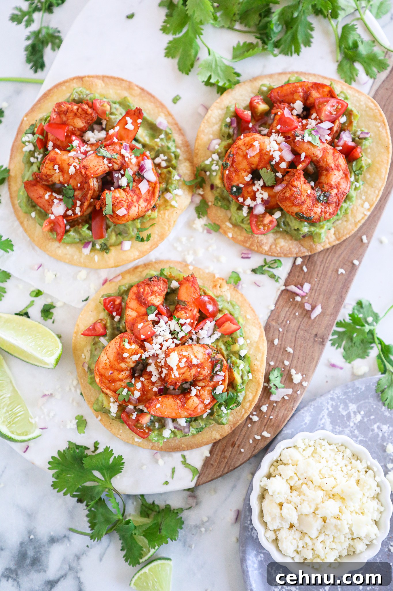 Spicy shrimp and creamy guacamole are served on top of a crispy tostada shell with all the taco fixings! This is one easy meal you won't get enough of!