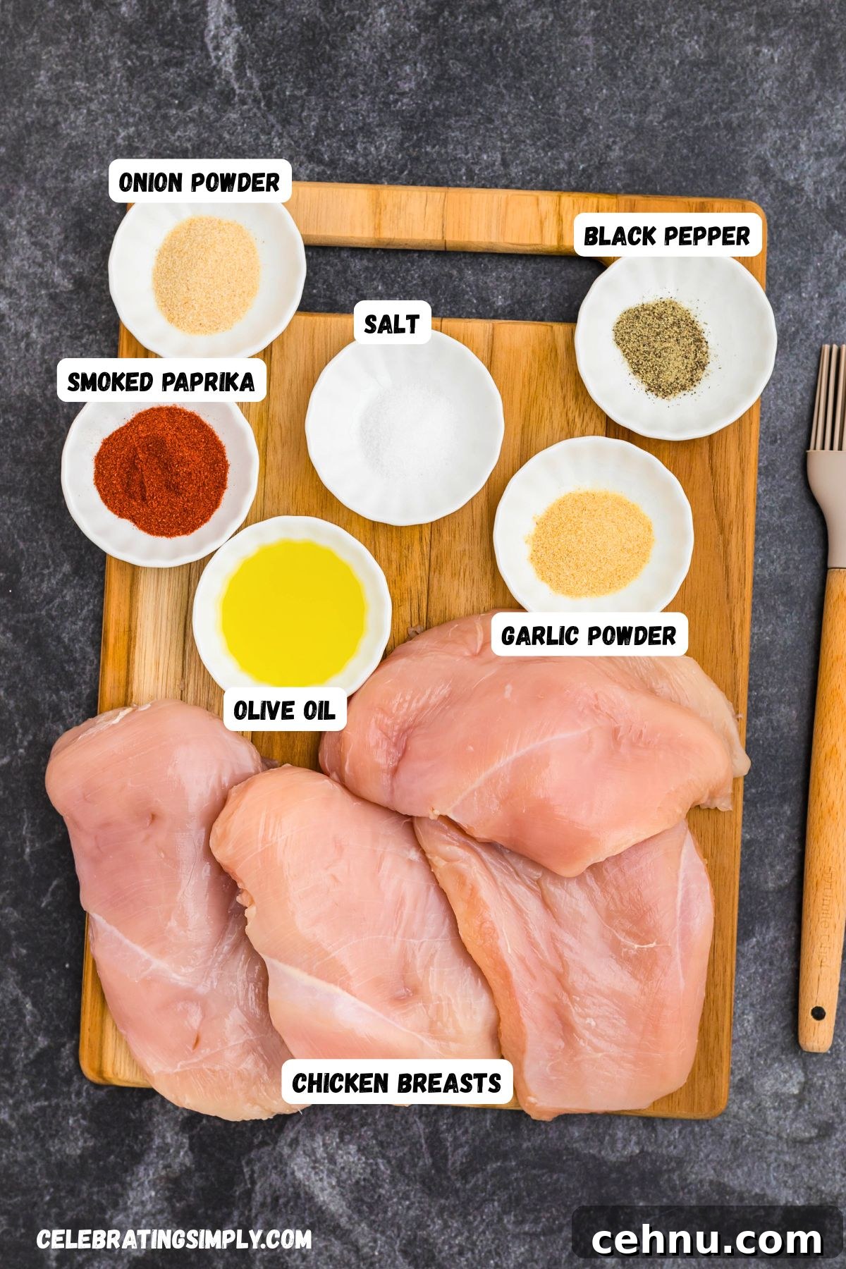 Ingredients measured into small white dishes on top of a cutting board with uncooked chicken breasts on the side. 