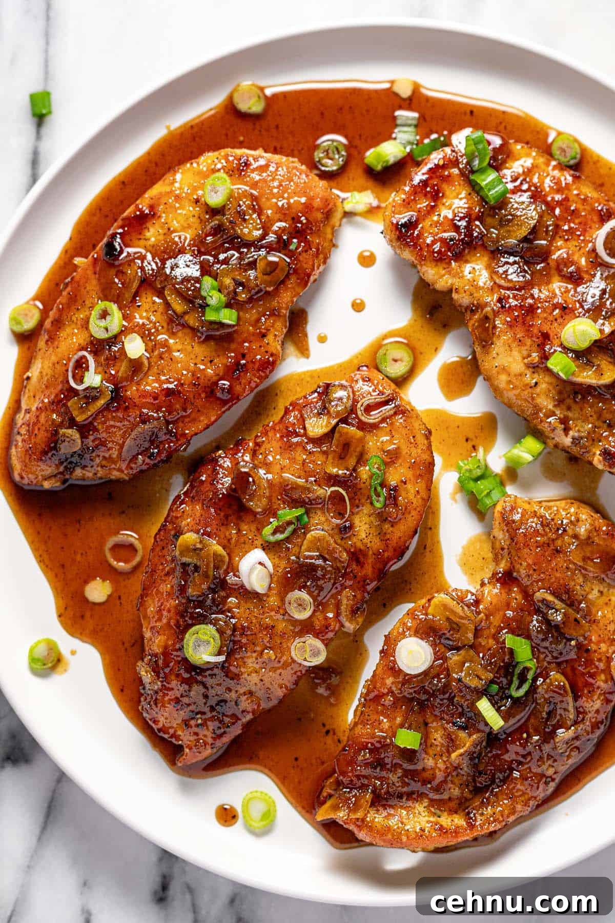 20-Minute Honey Garlic Chicken 2 Large round plate with honey garlic chicken garnished with sliced green onion.