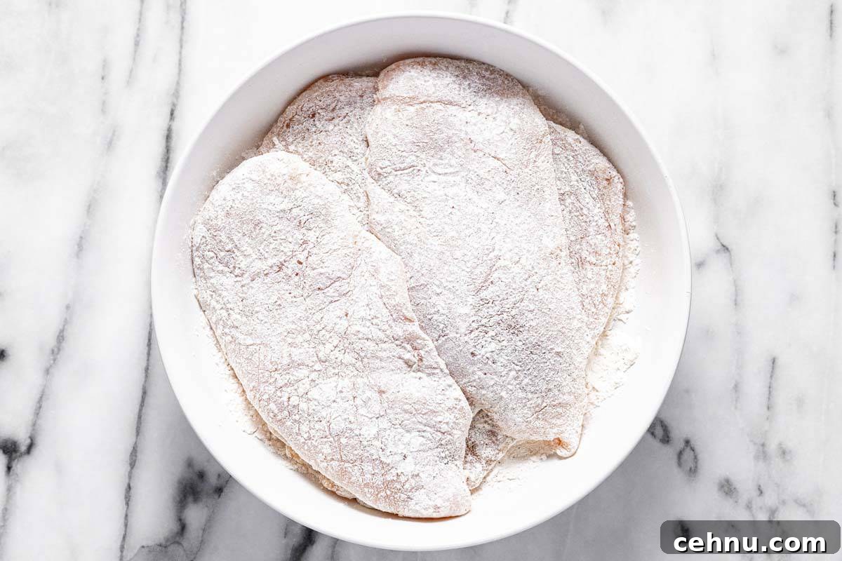 20-Minute Honey Garlic Chicken 4 Large bowl filled with flour dredged pieces of chicken breast.