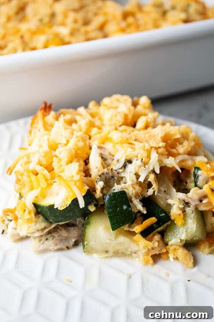 sideview of serving of keto and low carb chicken and zucchini casserole on a white plate