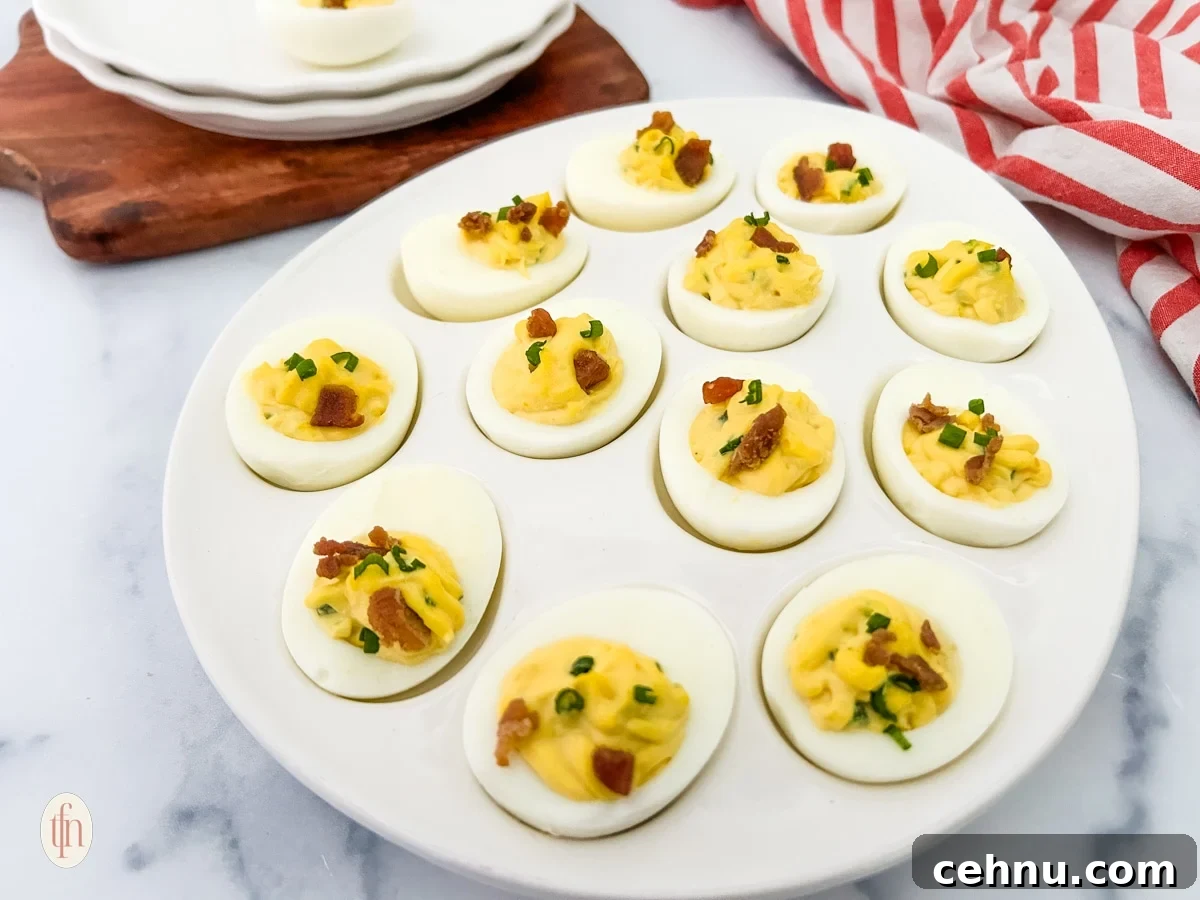 deviled eggs with jalapeno peppers on a white egg serving dish.