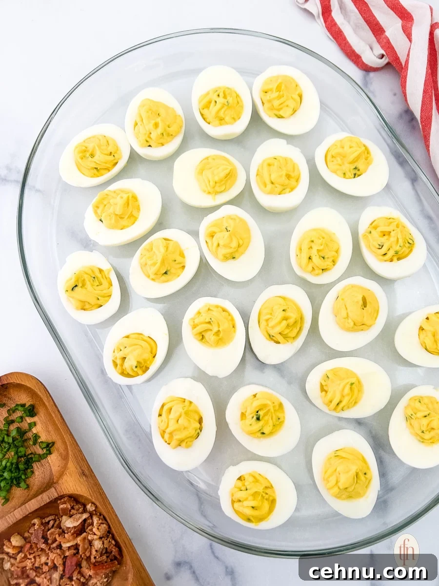 jalapeno bacon deviled eggs on a glass serving dish.