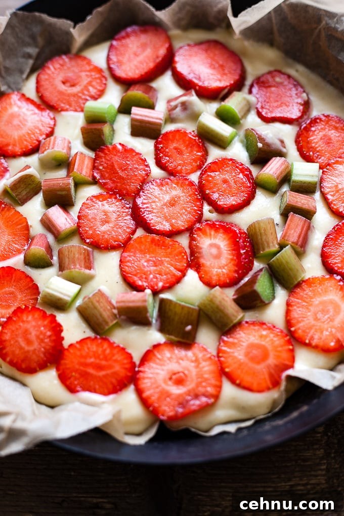 Strawberry rhubarb cake in a cake tin, before baking.