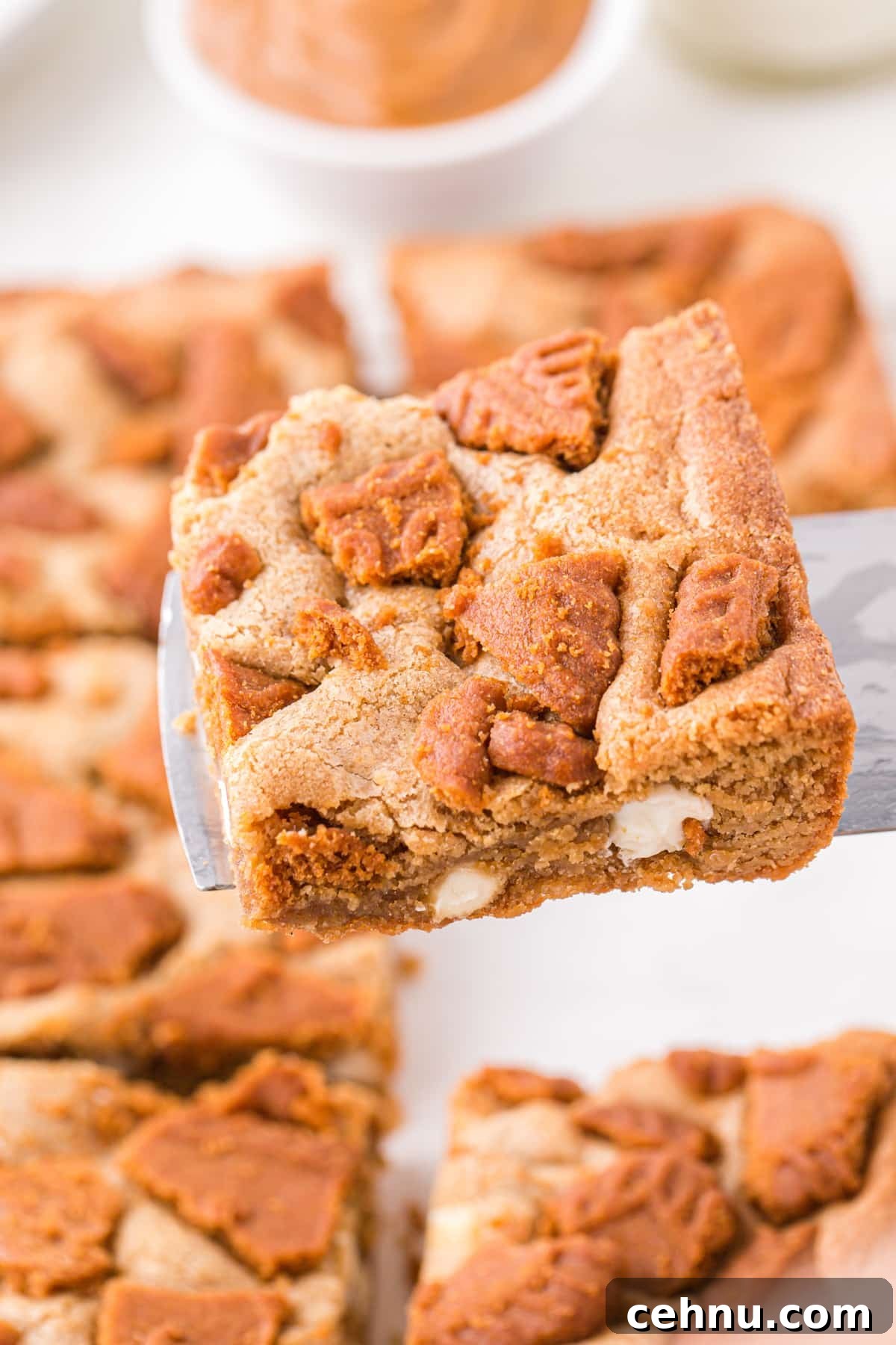 Lifting biscoff blondies from a pan.