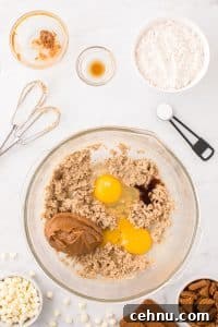 Mixing together creamed butter and sugar with eggs and cookie butter.