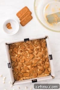 Topping a pan of blondies with biscoff cookies.