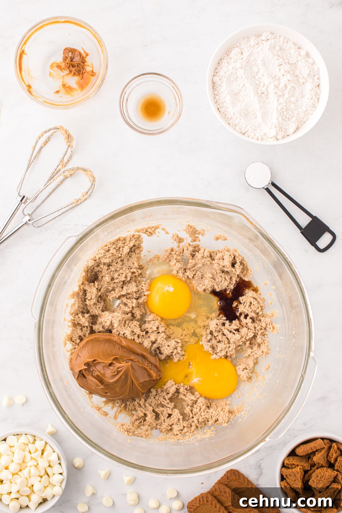 Mixing together creamed butter and sugar with eggs and cookie butter.
