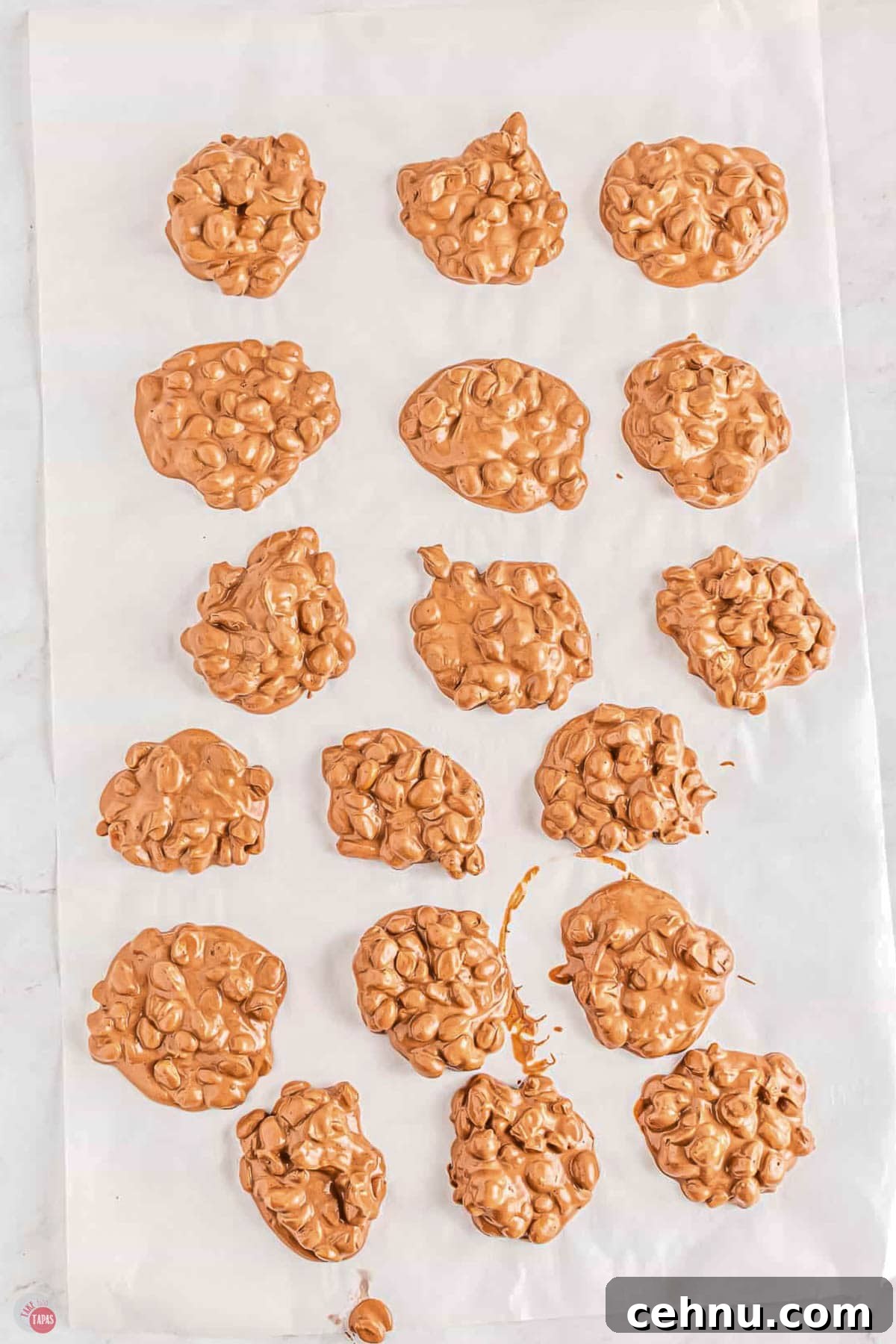 Slow Cooker Peanut Clusters: No-Bake Candy Recipe 7 parchment paper with mounds of chocolate and peanuts on it