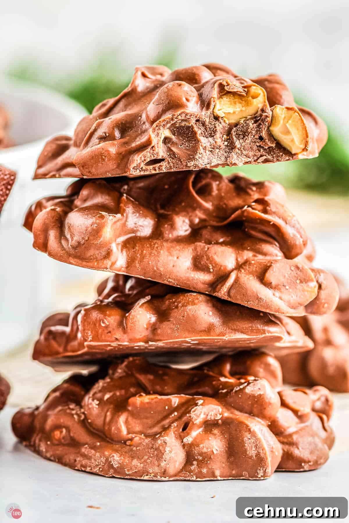 Slow Cooker Peanut Clusters: No-Bake Candy Recipe 9 stack of chocolate peanut clusters with a bite out of one of them