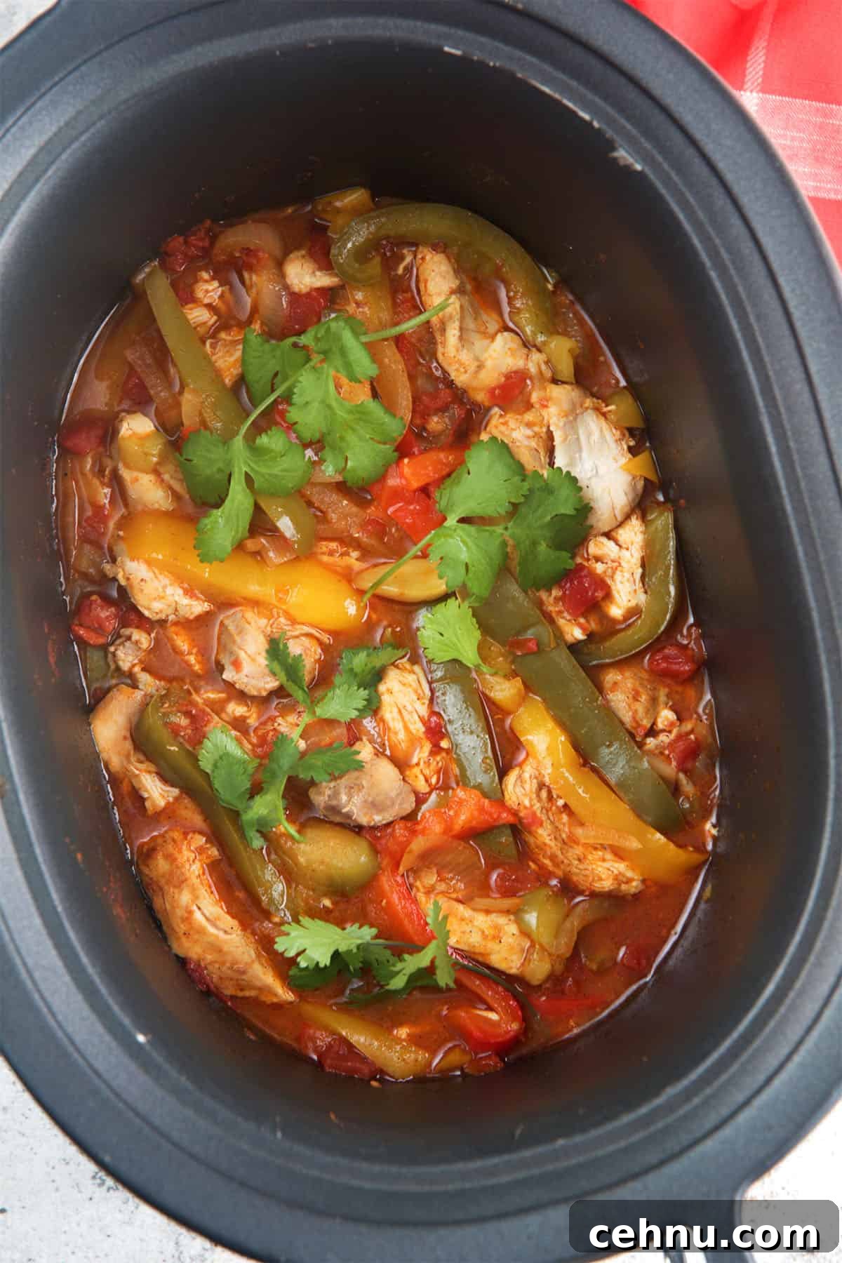 Slow cooker chicken fajitas in a black slow cooker.
