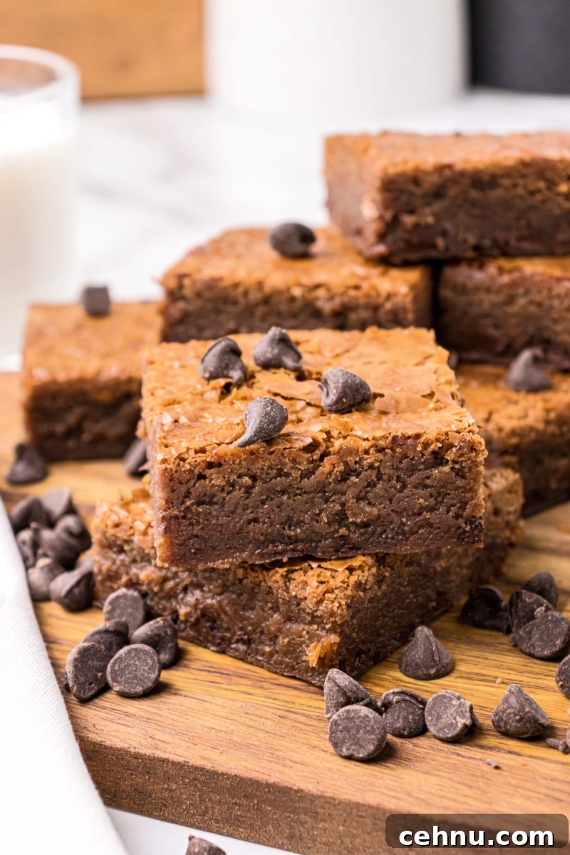brownies stacked on a cutting board with scattered chocolate chips