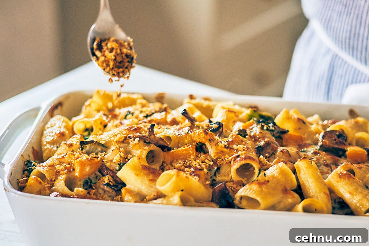 Sprinkling panko breadcrumbs over Cheesy Butternut Squash Pasta Bake.