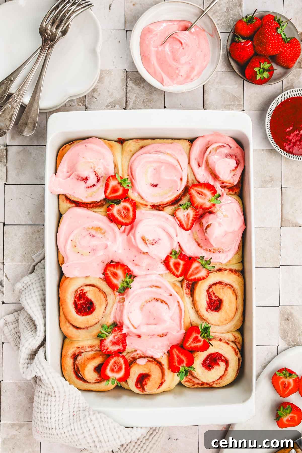 baked strawberry cinnamon rolls with strawberry cream cheese glaze on a table