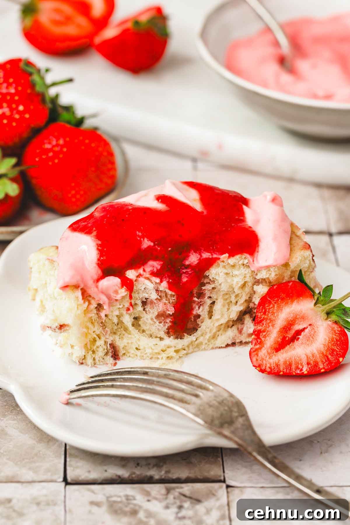 plate with strawberry cinnamon rolls topped with glaze