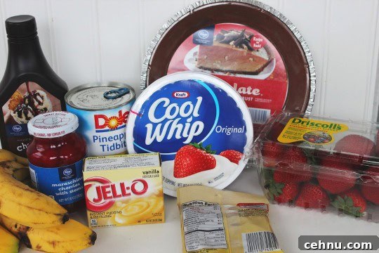 No-Bake Banana Split Pie Recipe 3 ingredients including Cool Whip, vanilla pudding, bananas, strawberries, cherries, and chocolate syrup.