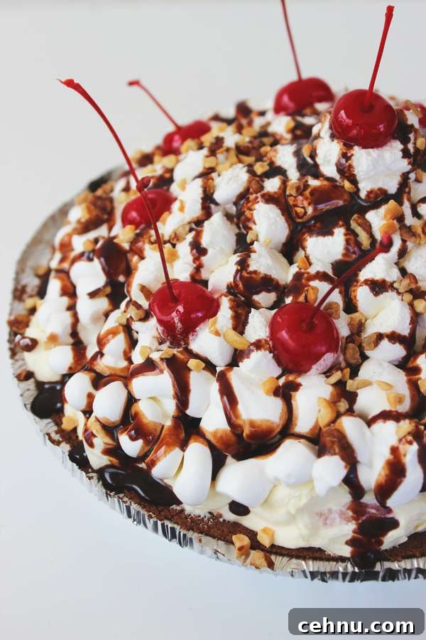 No-Bake Banana Split Pie Recipe 5 a pie in a chocolate cookie crust topped with bananas, peanuts, cherries, and chocolate syrup.