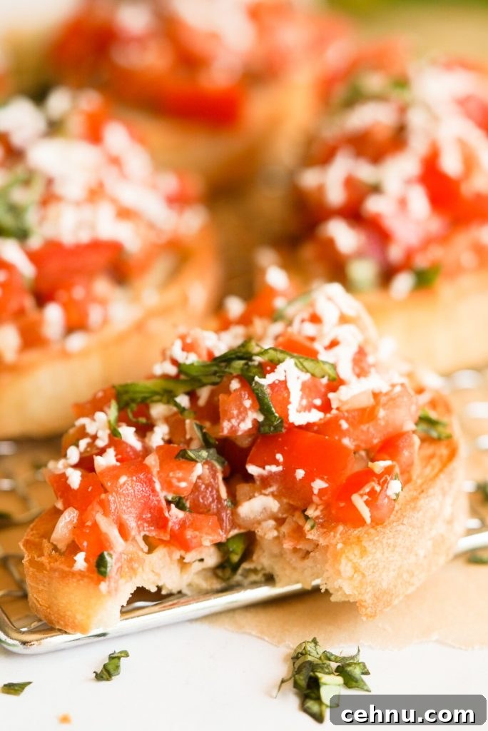 tomato bruschetta topped with goat cheese with a bite taken out