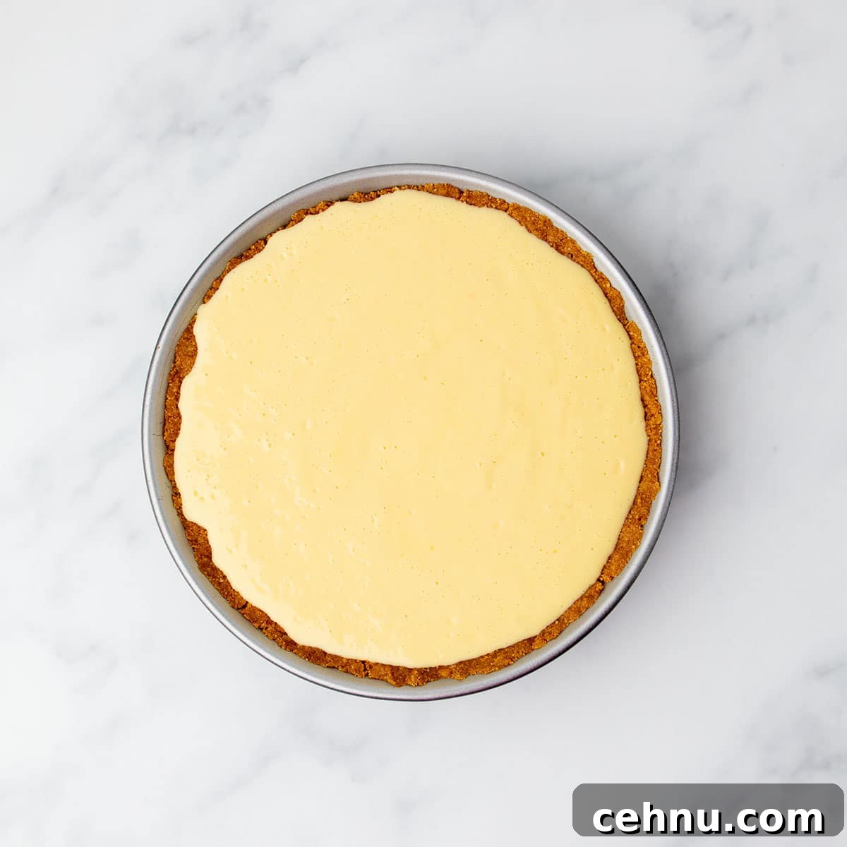 Unbaked gluten free lemon pie filling spread evenly in the cookie crust before baking.