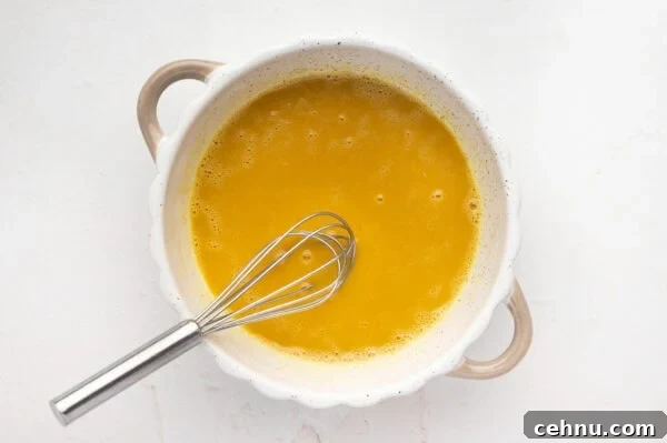 Classic Butter Cookies Recipe for Tea Time 5 Eggs and vanilla mixed together in a pot with a whisk.