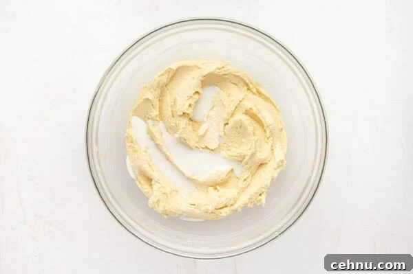Classic Butter Cookies Recipe for Tea Time 8 Milk added to wet ingredients for butter cookies in a glass mixing bowl