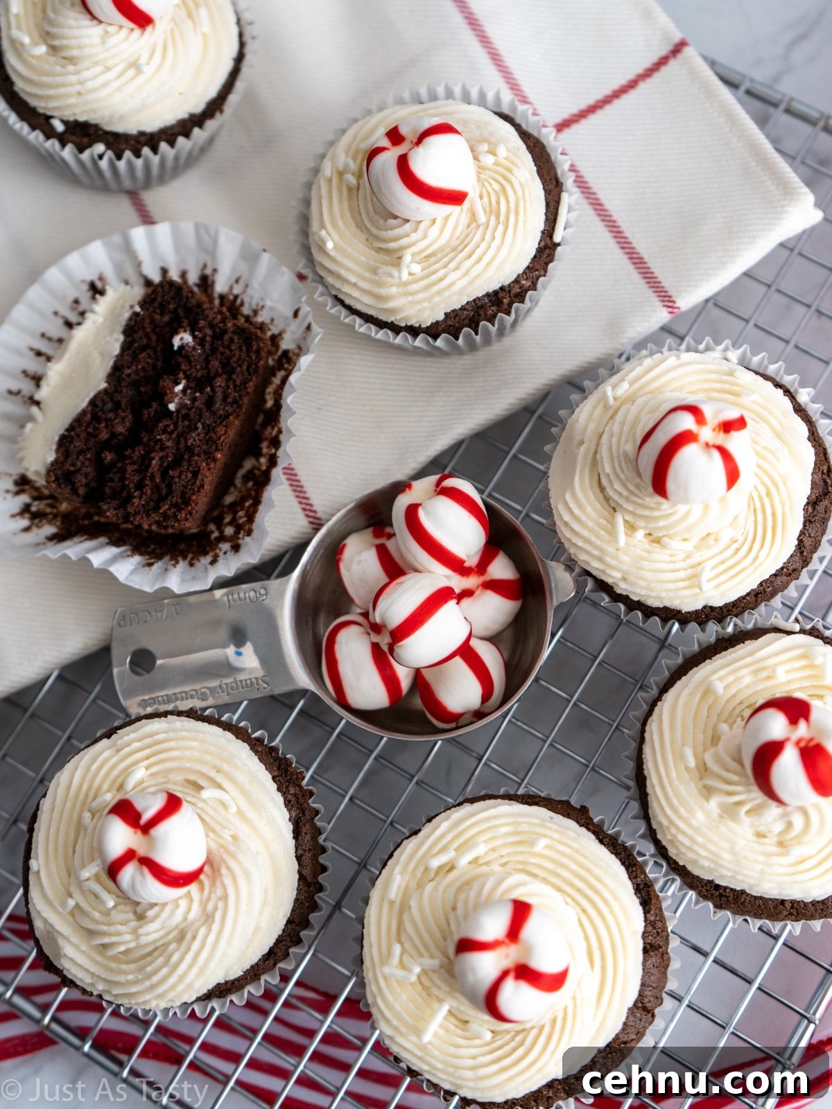 Decadent Chocolate Peppermint Cupcakes with Candy Cane Frosting 5 Frosted chocolate cupcakes, topped with red and white striped mints, on a wire cooling rack.