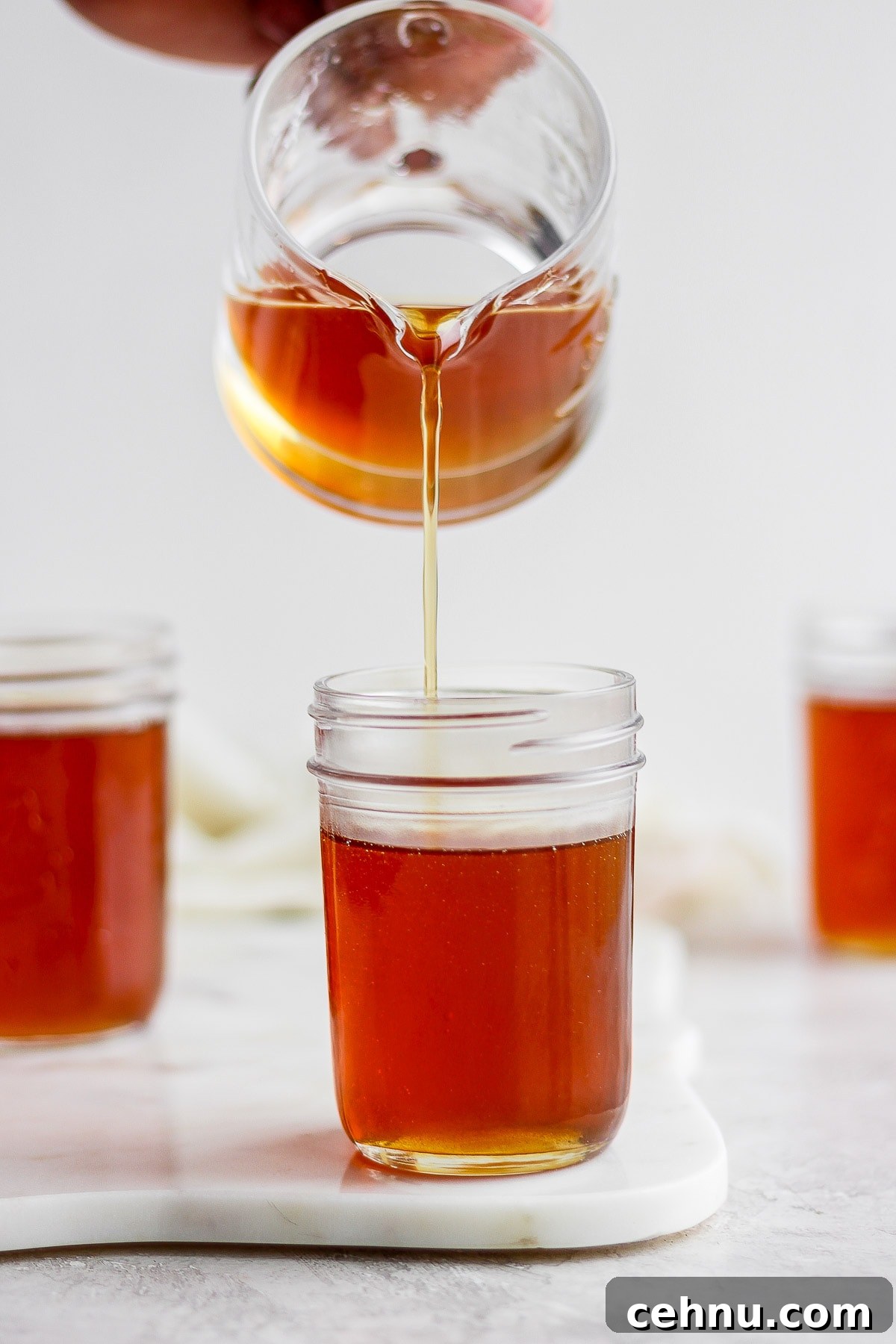 Maple Syrup being poured into a mason jar. 