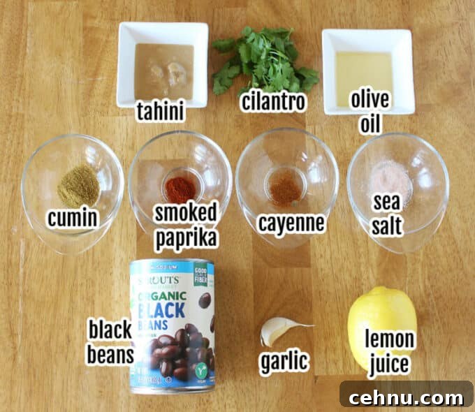 Various ingredients laid out on a table, including beans, tahini, and a lemon.