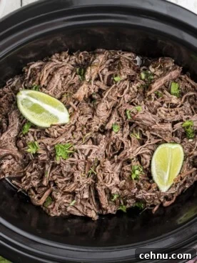 mexican shredded beef in slow cooker with 2 limes on top