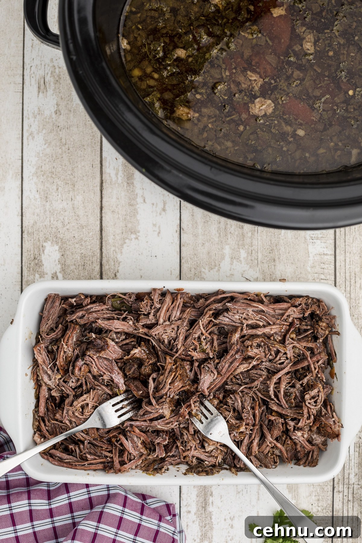 Beef being shredded on a plate.