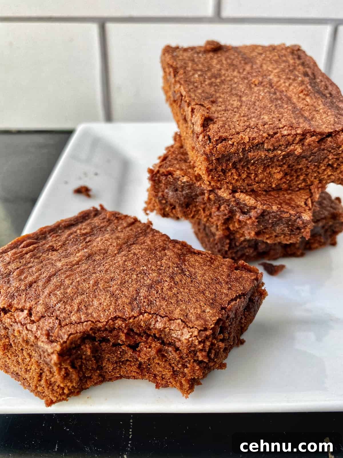 Homemade Brownie Mix Recipe for Fudgy Chocolate Brownies 6 Three brownies stacked on a plate, one in front with a bite taken out of it.