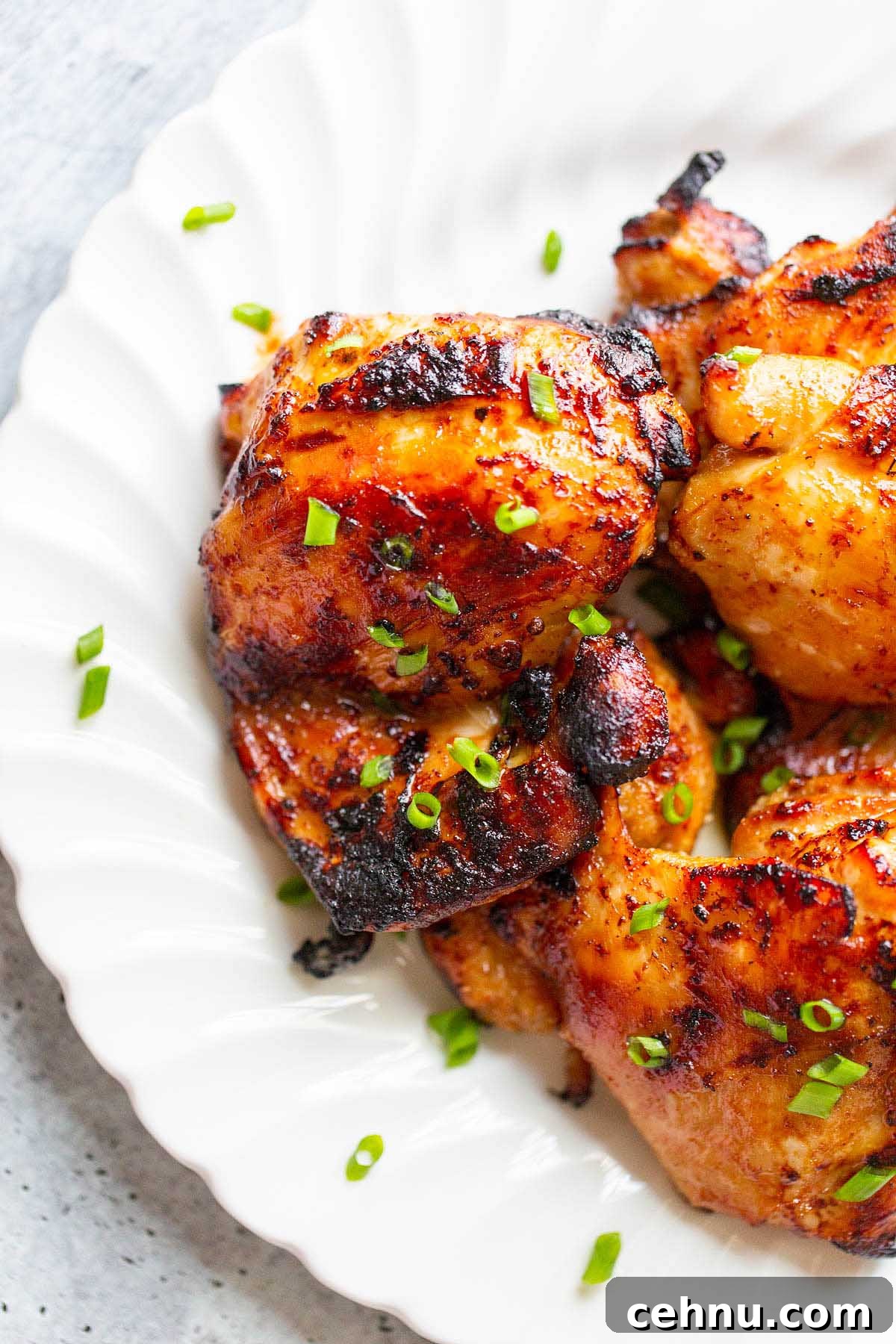 Crispy Honey Garlic Chicken Thighs in the Air Fryer 7 chicken thighs on a plate topped with green onions