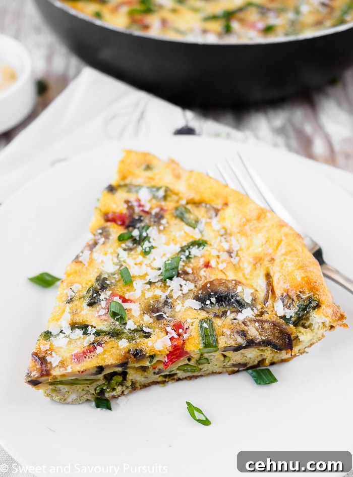 Vegetable Frittata with Spinach and Cherry Tomatoes 4 A serving of vegetable frittata on white dish