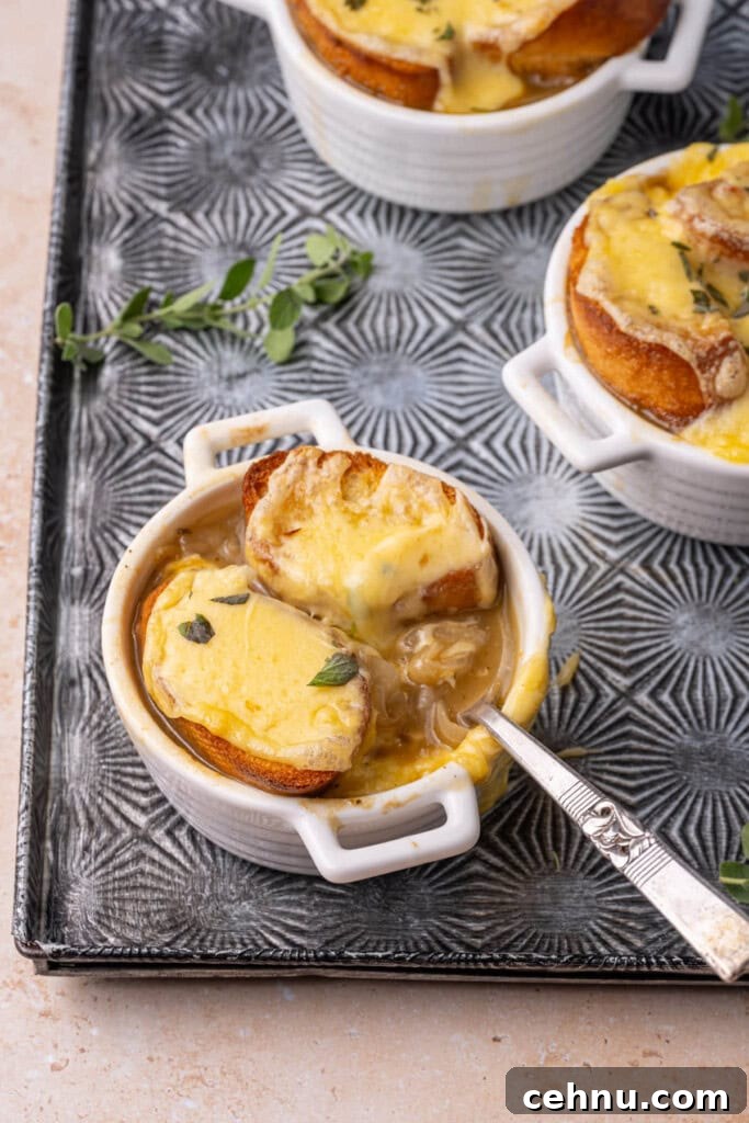 Vegetarian French onion soup with melty cheese and a spoon resting in it.