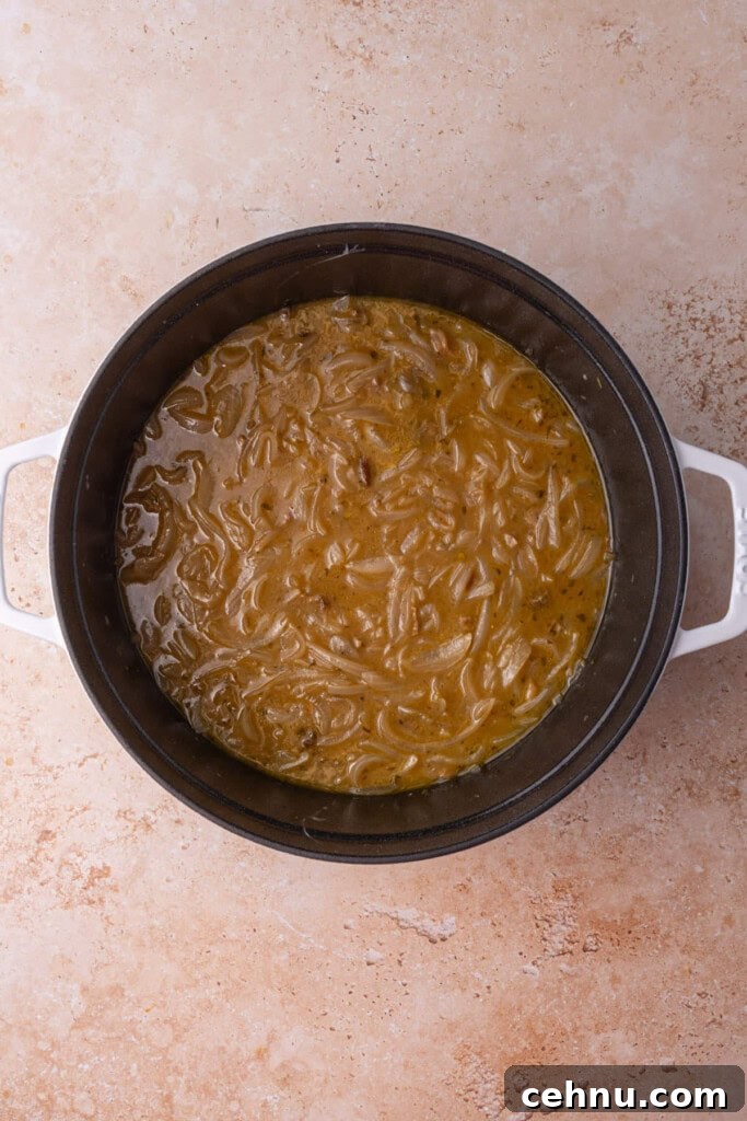Vegetarian French Onion Soup cooked in a cocotte before serving and adding bread and cheese.