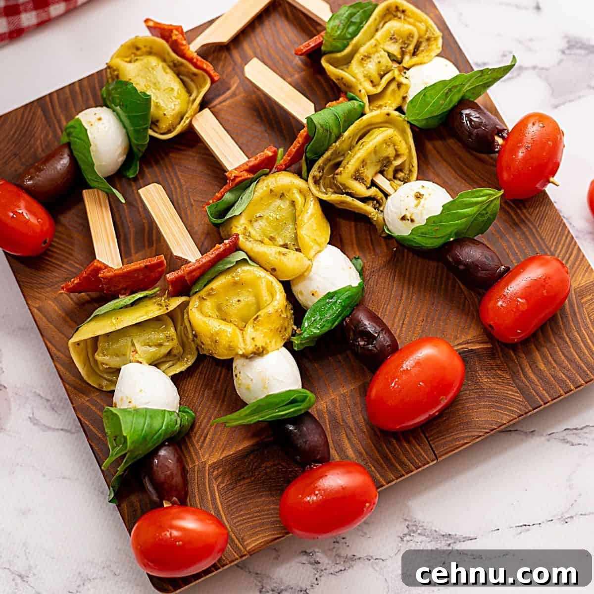 Antipasto Skewers with tomatoes and mozzarella on wooden cutting board ready to be served.