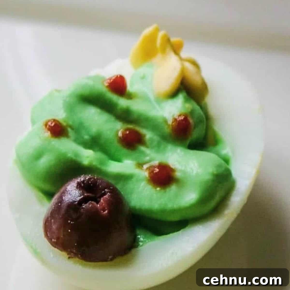Deviled egg with green filling made to look like Christmas tree.