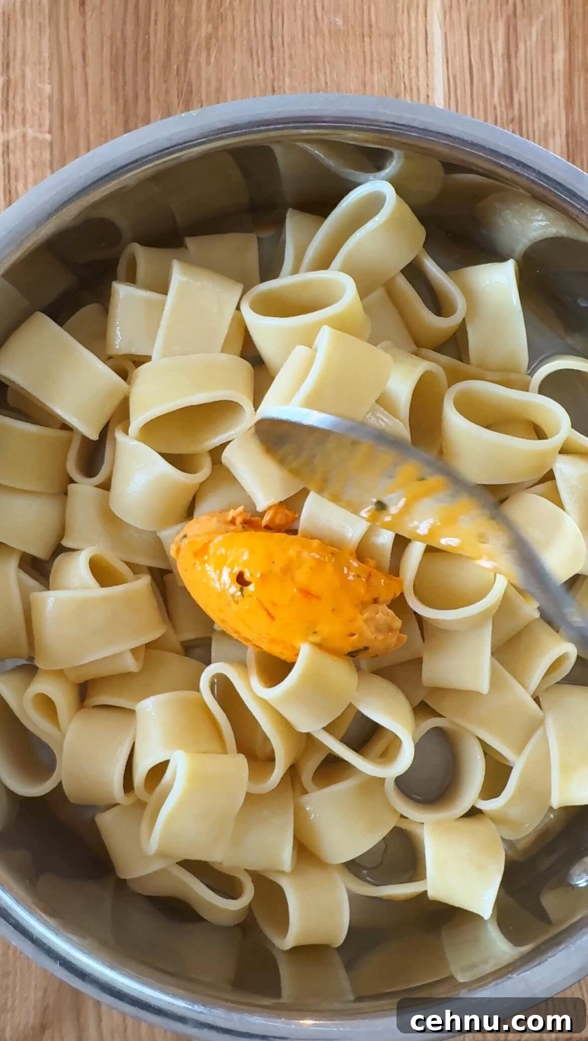 adding tomato butter to the pasta